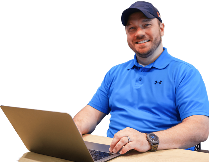 John Bendever, Chief Results Officer of ArborEdge Marketing, smiling at the camera in a blue polo and ball cap at his laptop
